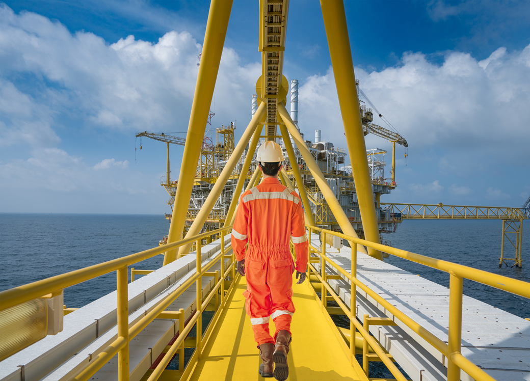An offshore oil rig worker walk to oil and gas central facility