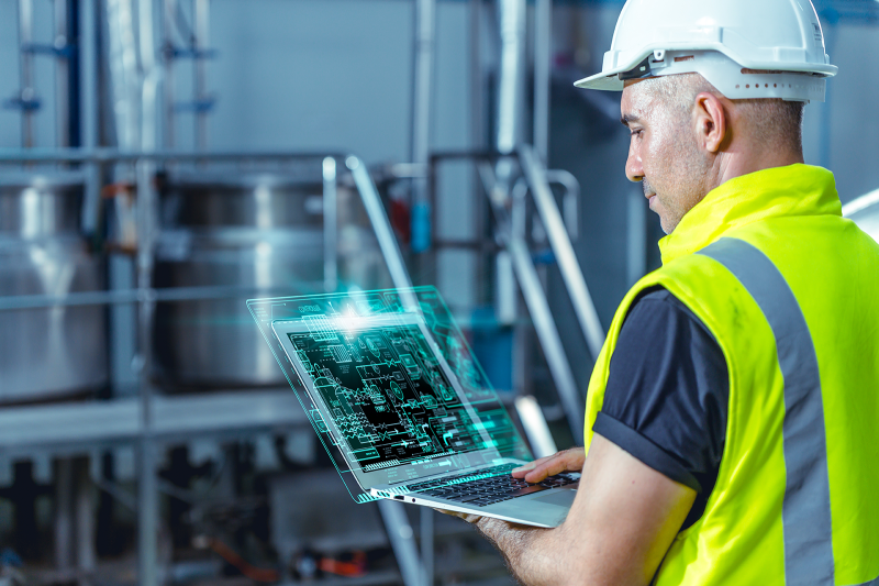 Engineer with laptop with digital refinery drawings