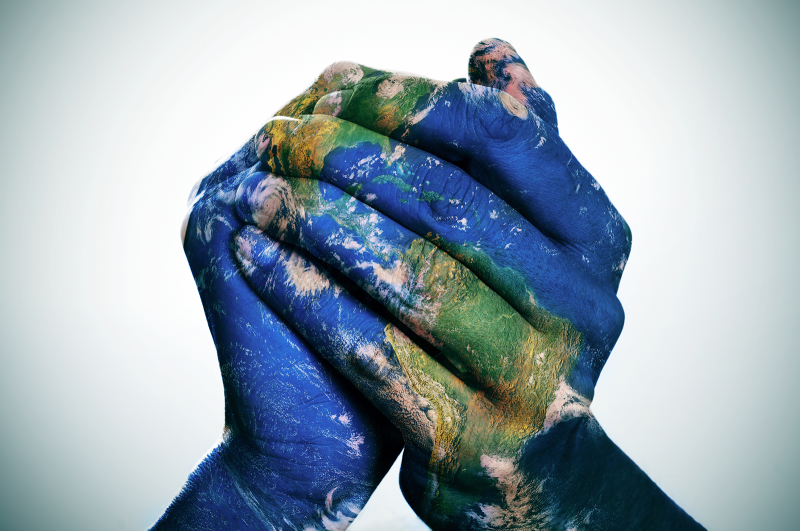 a world map in man hands forming a globe