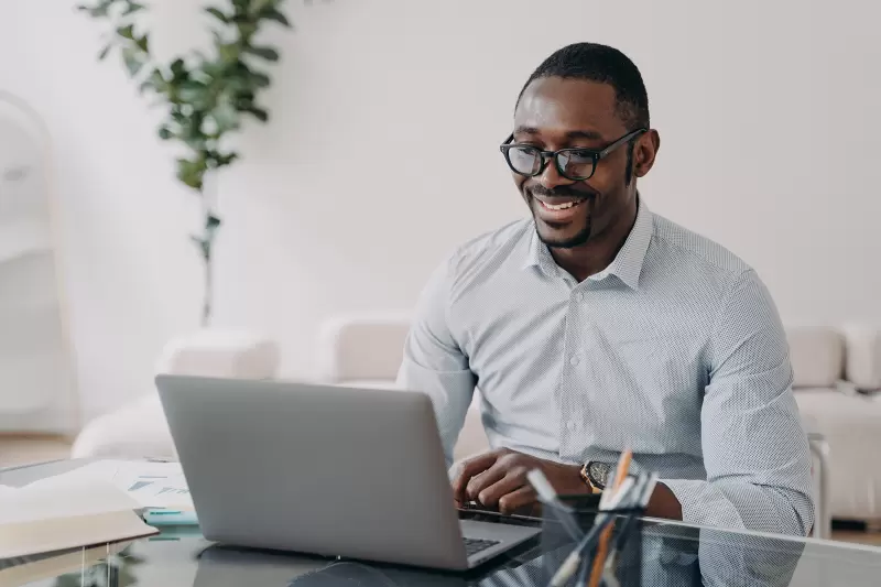 african american businessman wearing glasses working at laptop